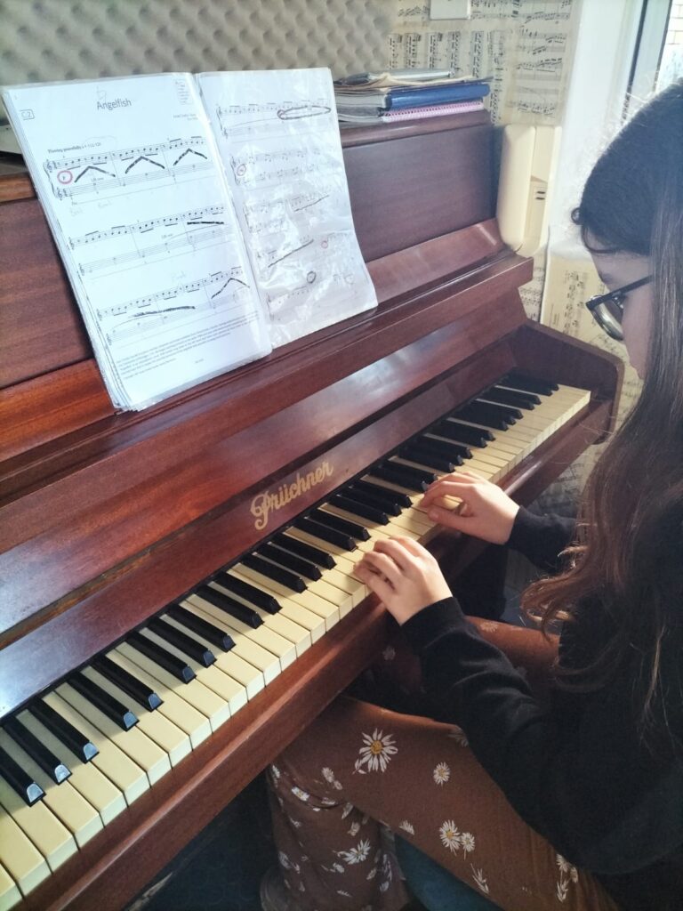 piano student playing instrument in music lesson new rising arts