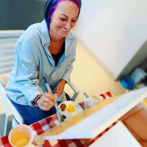 adult art student using acrylic paint on canvas